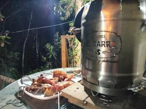 a grill with a plate of food on a table at Kai Ecoglamping in El Peñol