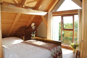 a bedroom with a bed and a large window at Beautiful Stone Riverside Retreat Galway in Galway +5 photos