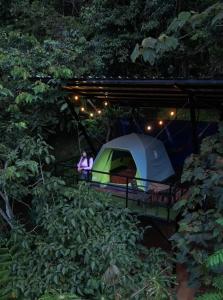 a woman standing next to a tent in the woods at Eco Meeting in Cali +34 photos