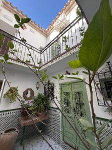 a courtyard of a house with a green door at Encanto Guesthouse in Canillas de Aceituno