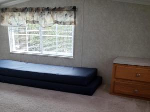 a bedroom with a bed and a window and a dresser at Baraboo RV Resort in Baraboo +8 photos