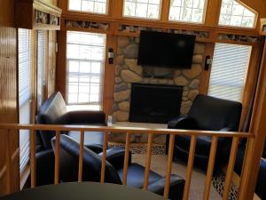 a living room with two chairs and a fireplace at Baraboo RV Resort in Baraboo
