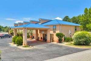 a building with a blue roof in a parking lot at Gray Inn & Suites in Gray