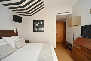 a bedroom with a bed and a flat screen tv at Hotel Principe Real in Lisbon