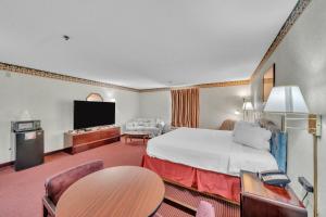a hotel room with a bed and a flat screen tv at Gray Inn & Suites in Gray