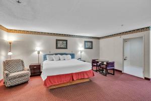 a large hotel room with a bed and a chair at Gray Inn & Suites in Gray +38 photos
