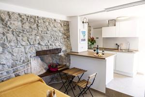a kitchen and living room with a stone wall at Casa Isca in Trentinara