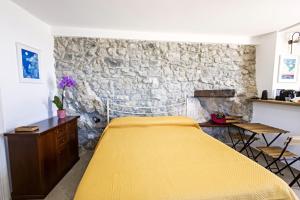 a bed in a room with a stone wall at Casa Isca in Trentinara +7 photos