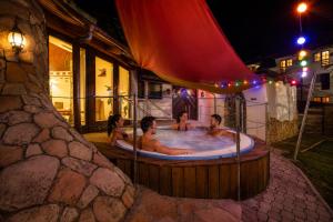 a group of people in a hot tub at night at Hotel Piroska in Bük