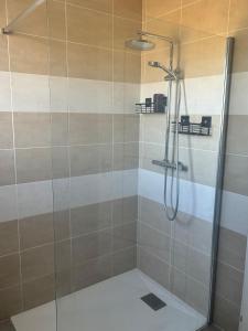 a bathroom with a shower with a glass door at Maison chaleureuse in Migron