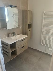 a bathroom with a sink and a mirror at Maison chaleureuse in Migron