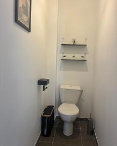 a bathroom with a toilet and shelves on the wall at Maison chaleureuse in Migron