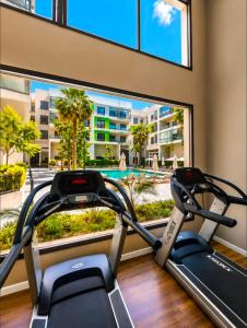 a gym with two treadmills and a large window at Le Jardin Secret - Pool View Elegance in Mohammedia