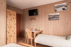 a bedroom with a table and a bed and a tv at U Trabanta - apartament, noclegi w centrum Bukowiny z widokiem na góry in Bukowina Tatrzańska