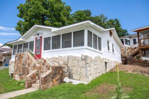 a white house with a stone wall at Historic Rockaway Beach Cottage 12 in Rockaway Beach