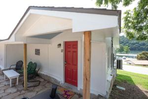 a small white house with a red door at Historic Rockaway Beach Cottage 12 in Rockaway Beach