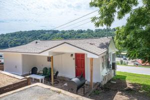 a small white house with a red door at Historic Rockaway Beach Cottage 12 in Rockaway Beach +10 photos