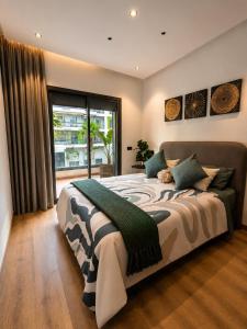 a bedroom with a large bed and a large window at Le Jardin Secret - Pool View Elegance in Mohammedia +28 photos
