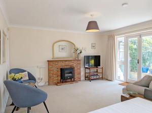 a living room with a fireplace and a tv at Apple Cottage - Emsworth in Emsworth