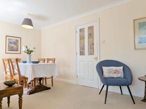 a dining room with a table and a blue chair at Apple Cottage - Emsworth in Emsworth