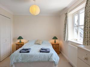 a bedroom with a bed and two lamps and a window at Apple Cottage - Emsworth in Emsworth