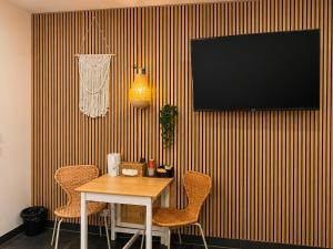 a dining room table with chairs and a television on a striped wall at Wellness Suite Zeist in Zeist