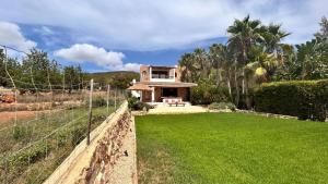 a house with a green lawn in front of it at SERENITY pool Ibiza Villa in Santa Eularia des Riu