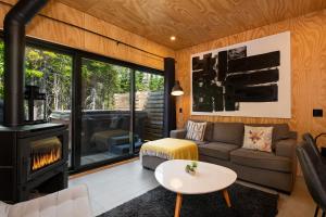 a living room with a couch and a stove at Les Refuges du Massif de Charlevoix in Petite-Rivière-Saint-François