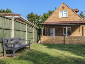 a bench sitting in a yard next to a building at Thames Retreat in Staines upon Thames