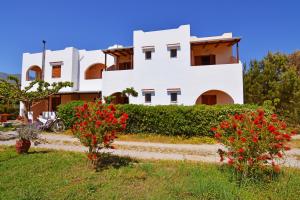 a white house with red flowers in front of it at Aeolos seaside studios in Frangokastello