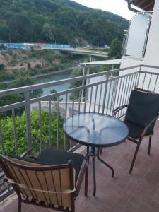 a table and chairs on a balcony with a view of a river at Drinika in Foča +5 photos