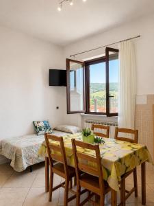 a dining room with a table and chairs and a bed at Appartamenti Camerota in Camerota