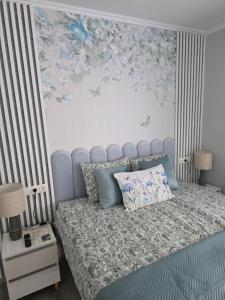 a bedroom with a bed with a blue head board at APARTAMENTI BrivdienuKolka in Kolka