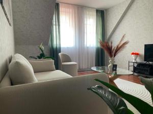 a living room with a white couch and a glass table at Astrum Apartman in Egerszalók