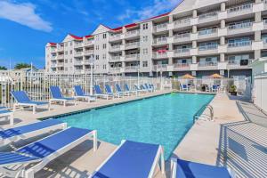 a swimming pool with lounge chairs and a hotel at White Marlin 202A in Ocean City