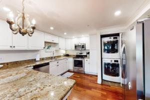 a kitchen with white cabinets and a refrigerator at White Marlin 202A in Ocean City +27 photos