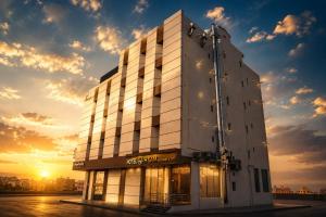 a building with the sunset in the background at H SAM Hotel in Taif
