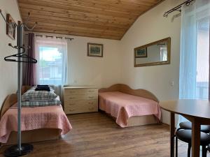 a bedroom with two beds and a table and a window at Magdelena in Palanga