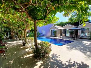 a backyard with a swimming pool and trees at Hotel Jaco Lodge in Jacó