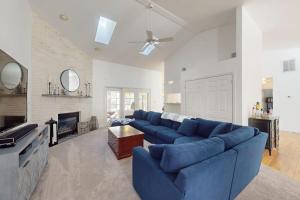 a living room with a blue couch and a fireplace at Salty Way in Ocean Pines