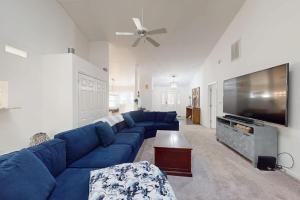 a living room with a blue couch and a flat screen tv at Salty Way in Ocean Pines