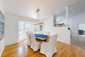a dining room with a table and white chairs at Salty Way in Ocean Pines +17 photos