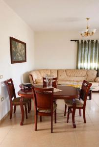 ein Wohnzimmer mit Tisch, Stühlen und Sofa in der Unterkunft Hamallaj in Hamallë