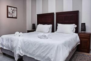 a bedroom with two beds with white sheets and towels at Rundu B&B in Rundu