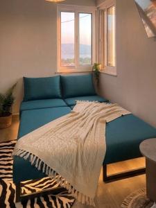a bed in a room with a blue couch at Skyline apartment Ioannina in Ioannina