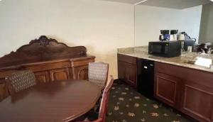 a kitchen with a wooden table and a microwave at SureStay Hotel by Best Western Eureka in Eureka