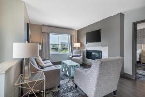 a living room with a couch and chairs and a fireplace at Best Western PLUS Franklin Square Inn in Troy