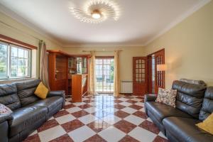 a living room with leather couches and a checkered floor at Família de Arega in Arega