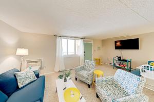 a living room with blue furniture and a flat screen tv at Colonial Unit 202 in Ocean City