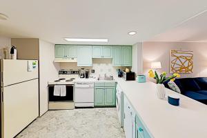 a kitchen with green cabinets and white appliances at Colonial Unit 202 in Ocean City